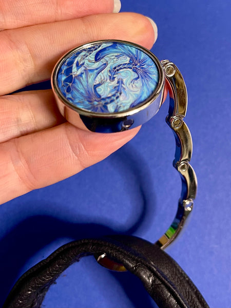 Blue dragon business hand bag hanger, keep in your handbag, unfurl hook to hang you hand bag form cafe or restaurant table. Keeps bag of the dirty floor and safe in your line of vision.