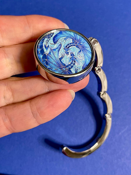 Blue dragon business hand bag hanger, keep in your handbag, unfurl hook to hang you hand bag form cafe or restaurant table. Keeps bag of the dirty floor and safe in your line of vision.