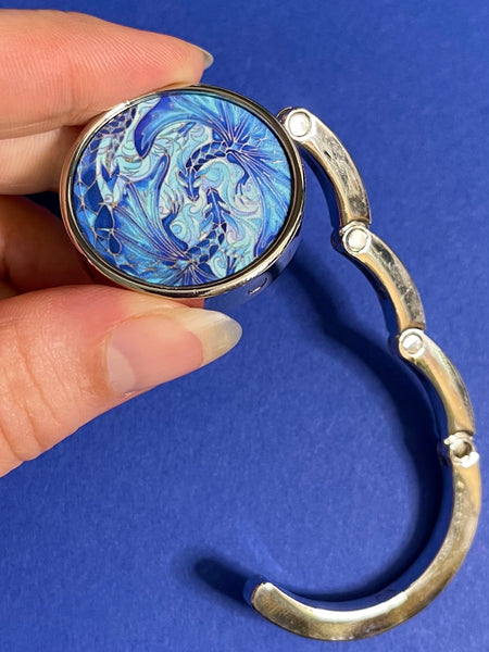 Blue dragon business hand bag hanger, keep in your handbag, unfurl hook to hang you hand bag form cafe or restaurant table. Keeps bag of the dirty floor and safe in your line of vision.